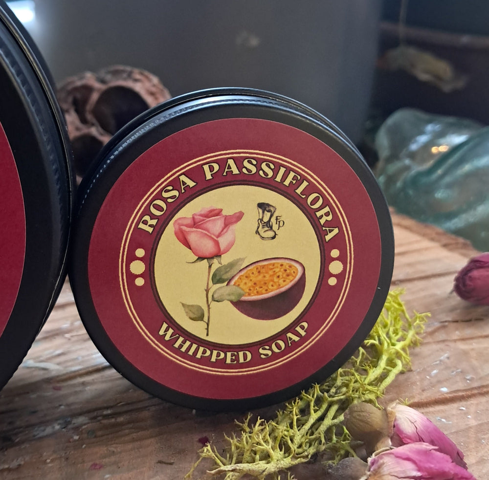 Rosa Passiflora whipped soap container with a decorative label on a wooden surface.
