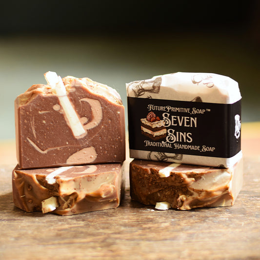 Three bars of soap with a 'Seven Sins' packaging on a wooden surface.