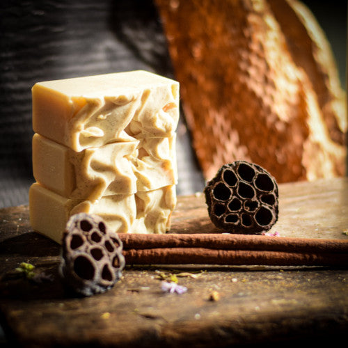 Three bars of soap with natural textures on a wooden surface