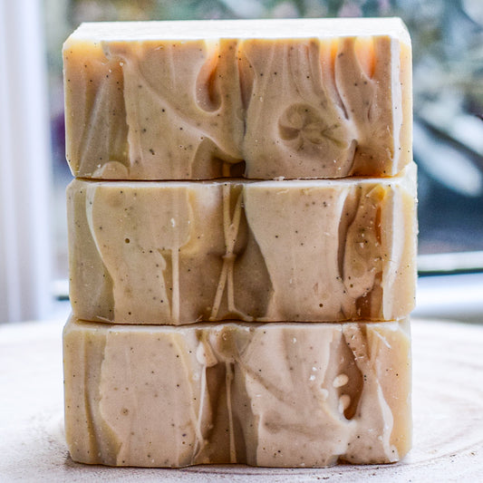 Stack of three handmade artisan soap bars on a neutral background