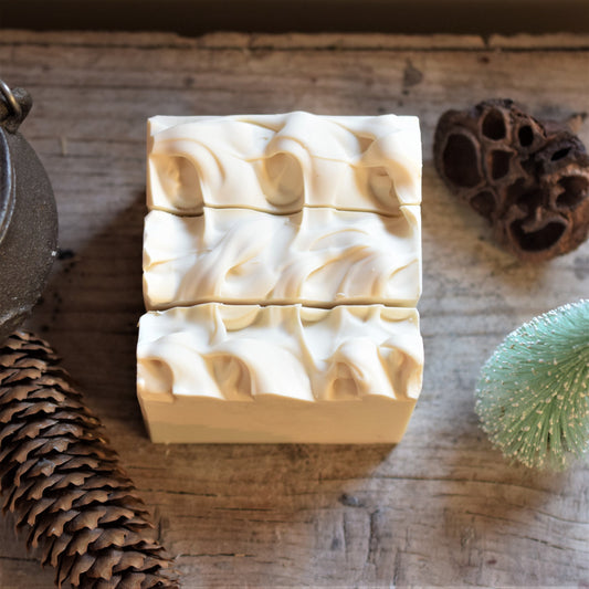 Snowdrift soap sat on a wooden table surrounded by natural elements