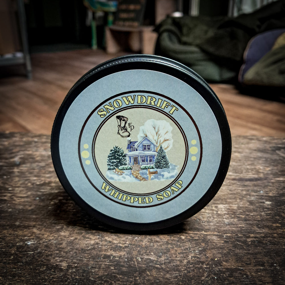 snowdrift whipped soap sitting on a dark wooden table.