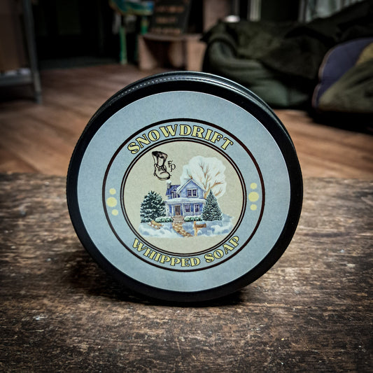 snowdrift whipped soap sitting on a dark wooden table.