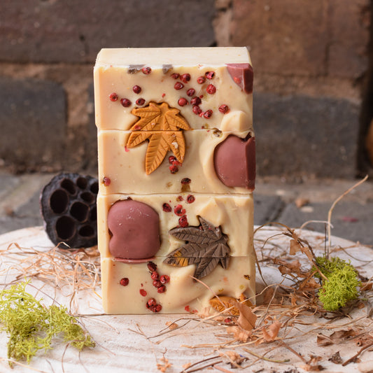Stack of decorative soap bars with natural elements on a rustic background