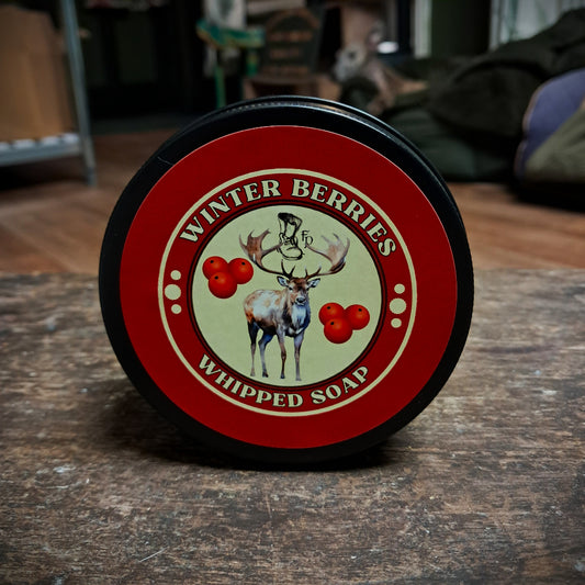 winter berries whipped soap in a black tin sitting on a wooden table
