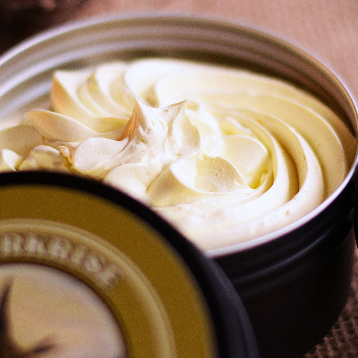 Creamy whipped soap in a tin with 'Larkrise' text and burlap background