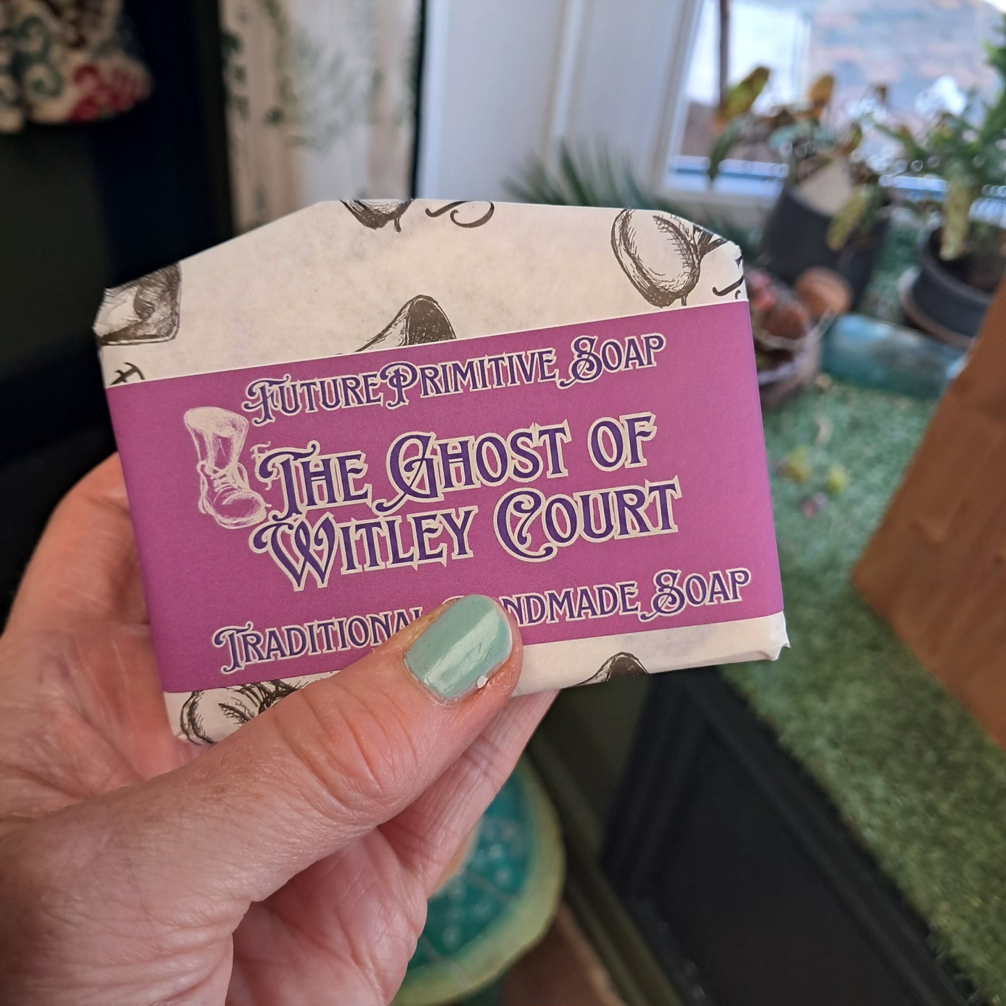 Hand holding a bar of soap with a purple label featuring text and graphics.