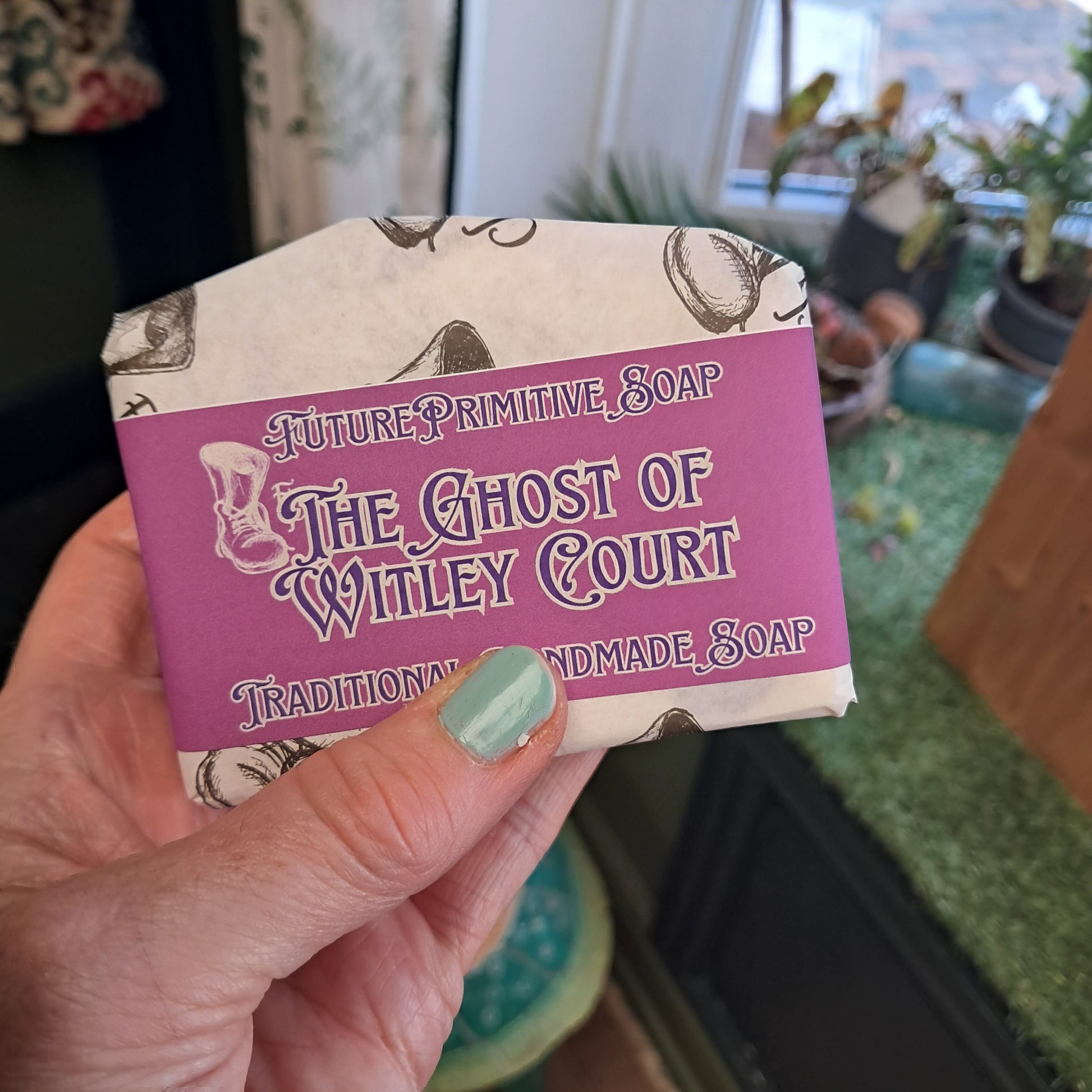 Hand holding a bar of soap with a purple label featuring text and graphics.