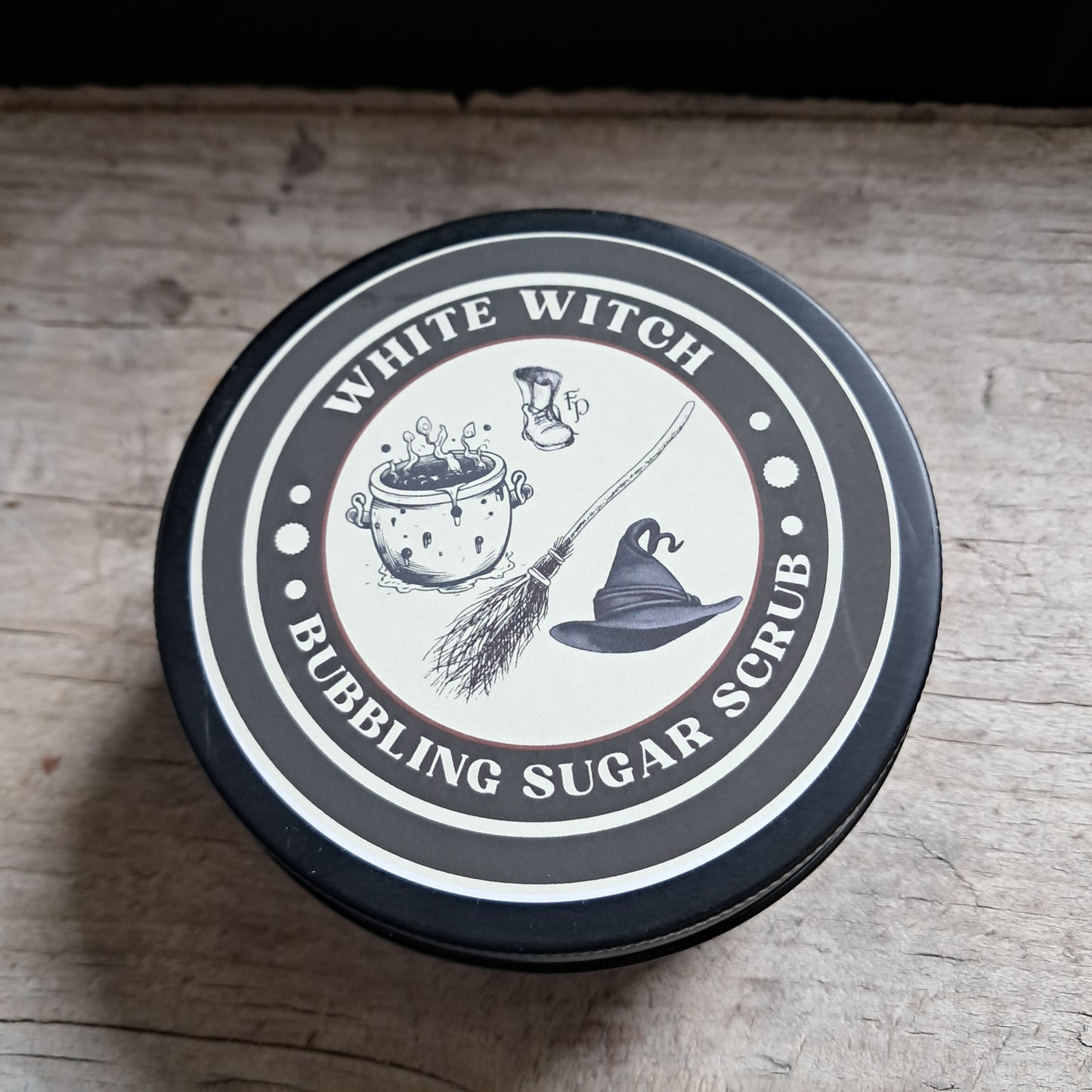 Container lid with 'White Witch' branding and graphics on a wooden surface