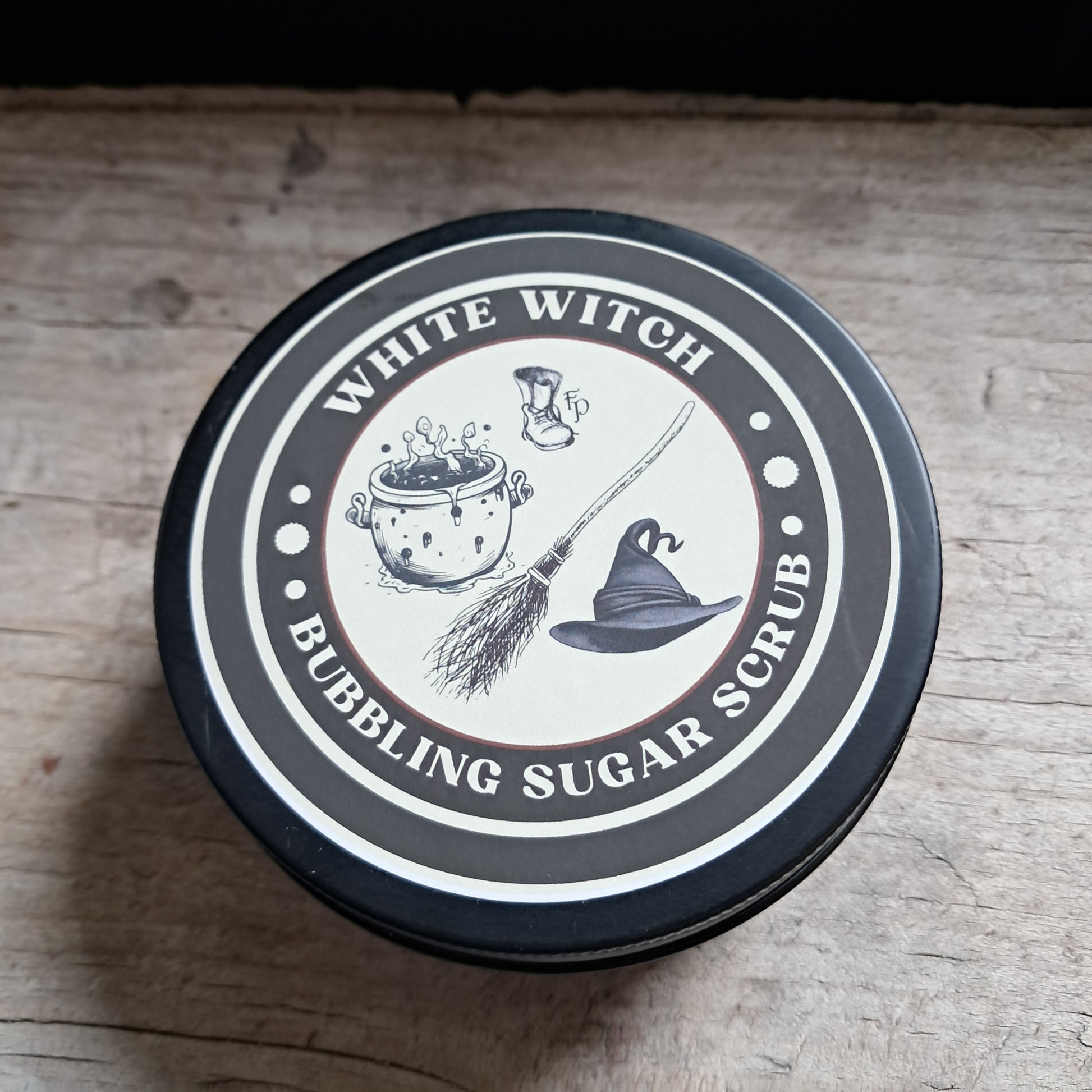 Container lid with 'White Witch' branding and graphics on a wooden surface